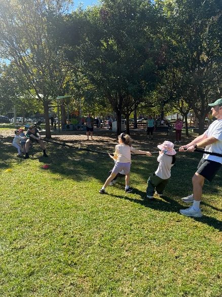 Children playing an active game with a coach on the grass